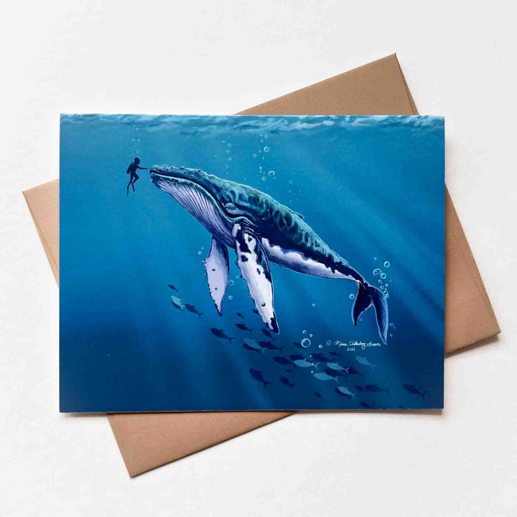 a notecard featuring a diver reaching out to touch an enormous humpback whale in the deep blue sea