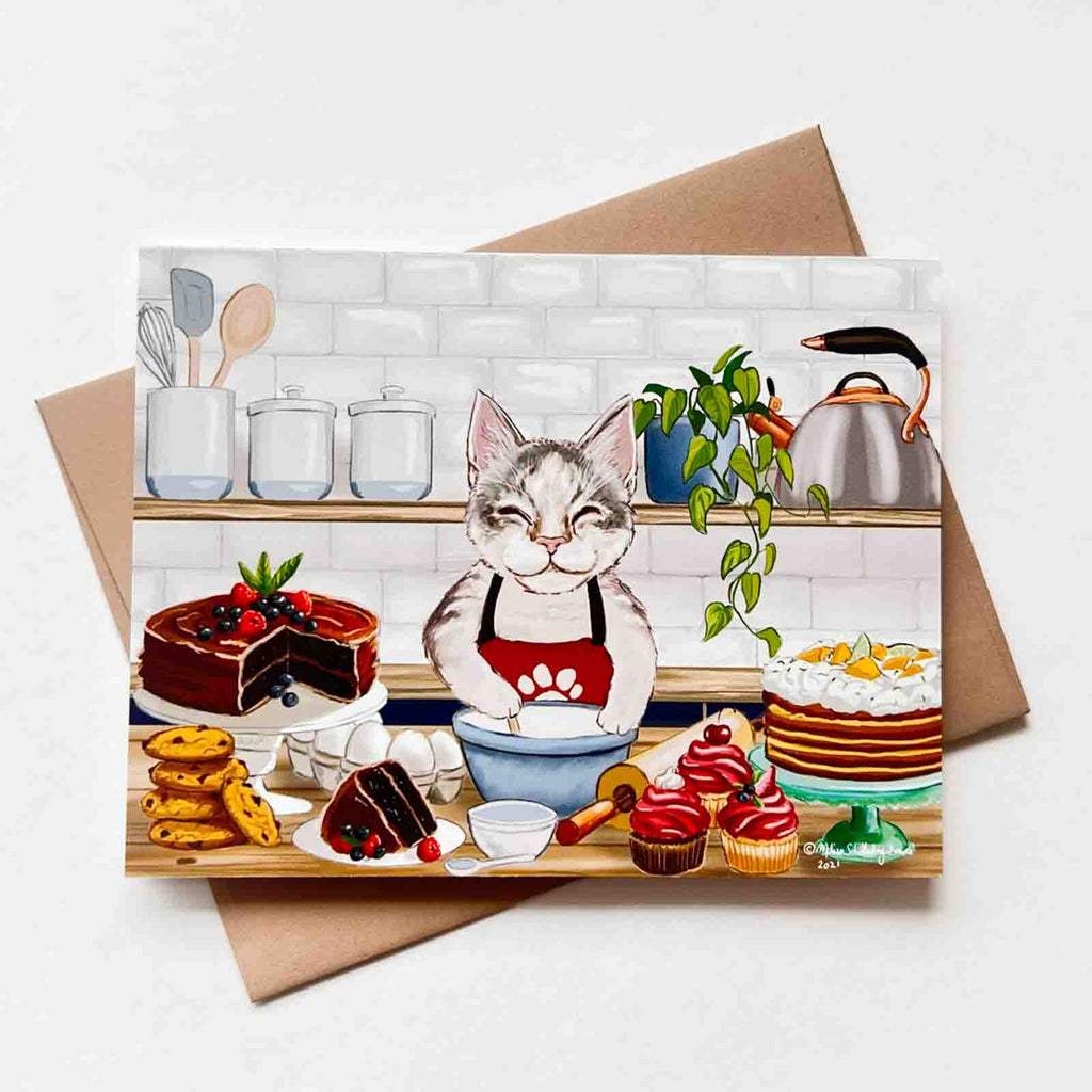 a whimsical notecard featuring a cat pastry chef in his kitchen, surrounded by cakes, desserts, and baked goods