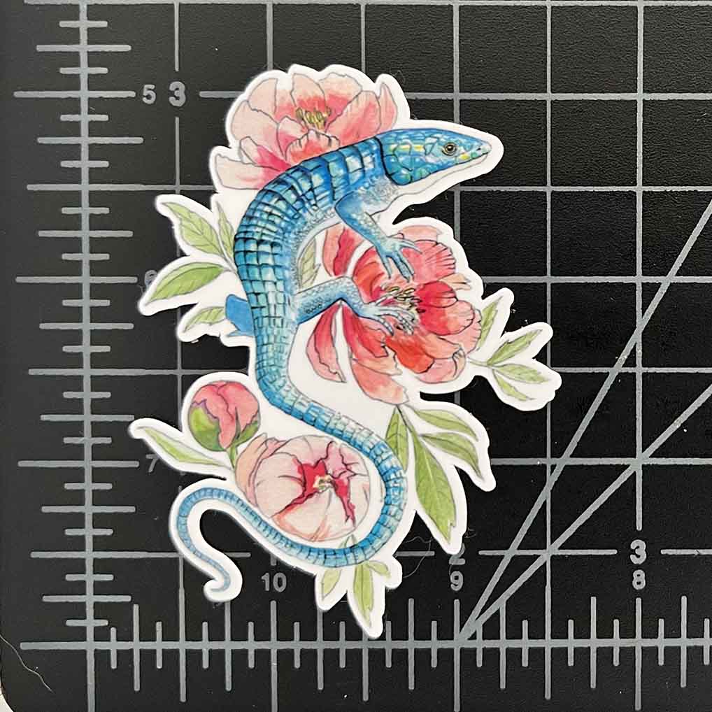 a 3 inch vinyl sticker of a abronia aka Mexican Alligator lizard resting on peony flowers